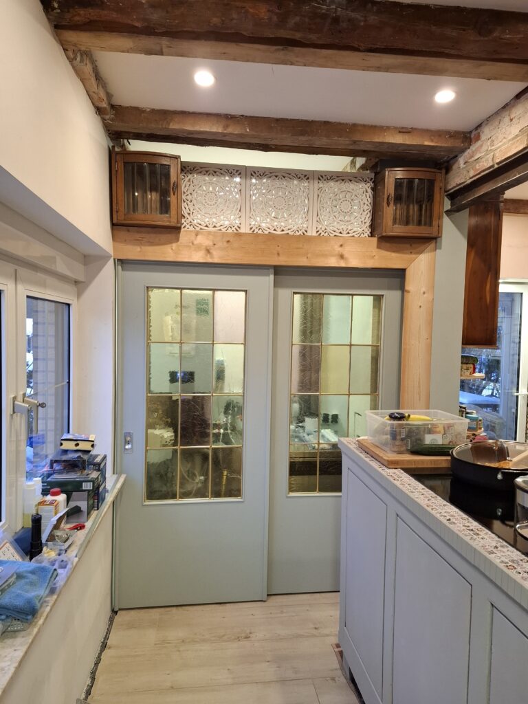 Schiebetüren Element in Küchennische eingestzt und mit Massivholbrettern verkleidet