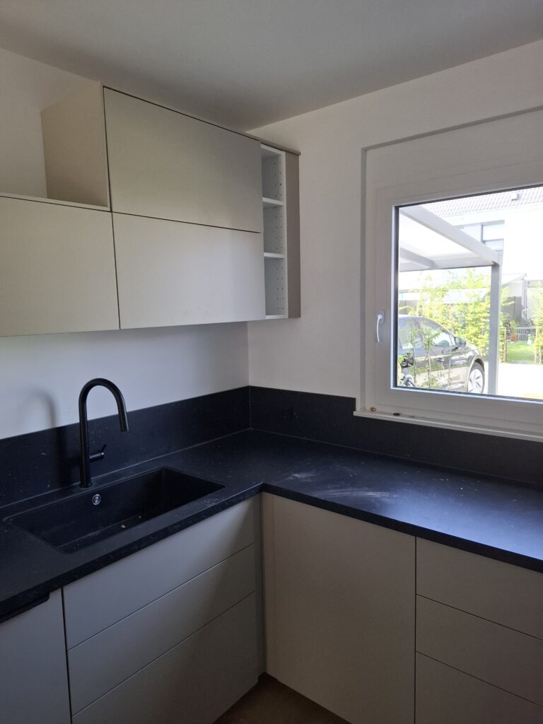 Küchenmontage mit Walnussfarbener Küche in L-Form mit Spühle, Herd und Hängeschränken